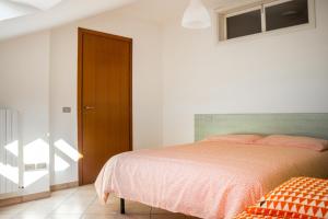 a bedroom with a bed and a wooden door at APPARTAMENTO "ARANCIO" SUL MARE in Cupra Marittima