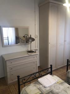 een slaapkamer met een dressoir en een spiegel aan de muur bij le Rose di santina in Mamoiada