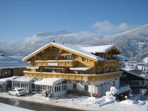 ein großes Holzhaus mit Schnee darüber in der Unterkunft Ferienwohnungen Fellhornblick in Riezlern