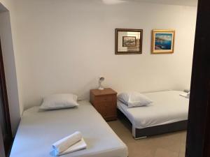 Dos camas en una habitación con dos toallas. en Jurisic apartments, en Novalja