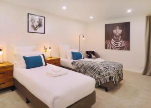 une chambre avec deux lits et un tableau au mur dans l'établissement Executive Living in Bluewater, à Queenstown