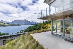 une maison sur une colline avec vue sur un lac dans l'établissement Executive Living in Bluewater, à Queenstown