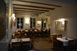 a dining room with tables and chairs and a mirror at Apartament Stara Kamienica in Kętrzyn
