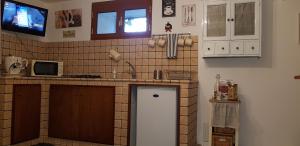 a kitchen with a refrigerator and a tv on the wall at Tabor 1 casa vacanza in villa in Naples