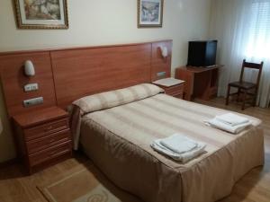 a bedroom with a bed with two towels on it at Hotel 2 de mayo 2 in Xinzo de Limia