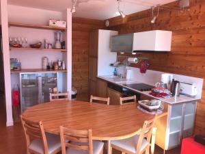 una cucina con tavolo e sedie in legno di Appartement pied des pistes avec balcon & vue 6 personnes a Orcières