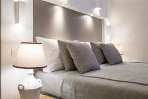 1 dormitorio con 1 cama con almohadas y lámpara en ReLuxe Private Wellness en Lecce