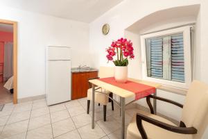 a kitchen with a table with a vase of flowers on it at Damira Rooms in Split