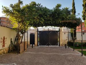 Una gran puerta con un árbol delante. en Tabor 1 casa vacanza in villa, en Nápoles