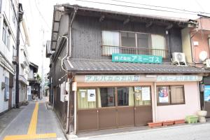 a building with a sign on top of it on a street at Share House Amigos in Onomichi