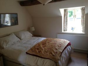 a bedroom with a bed and a window at Brook Cottage in Chipping Campden