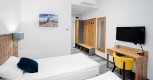 um quarto com uma cama, uma secretária e uma televisão em Hotel Nowa Holandia em Elblag