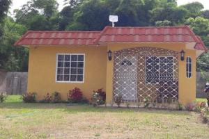 a small yellow house with a red roof at Wilks Villa in Knowles