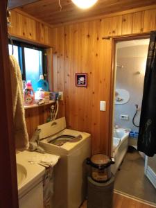 a bathroom with a sink and a washing machine at Minpaku Sarai Nikkoya in Okkia