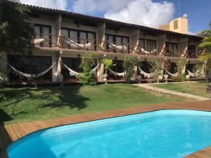 a house with a swimming pool in front of it at Pousada Mãe Natureza in Pipa
