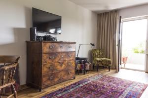 a room with a dresser with a television on top at seeglueck SONNENSCHEIN uni nahes und See nahes Apartment mit großem Südbalkon und Tiefgaragenstellplatz in Konstanz