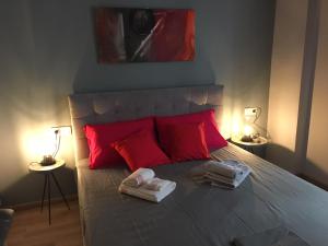 a bedroom with a bed with red pillows and towels at Bring only your toothbrush! in Athens