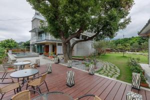 un patio con mesas, sillas y un árbol en Hou Shan Ren Jia B&B Hall A en Yung-an-ts'un