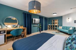 Schlafzimmer mit blauen Wänden, einem Bett und einem Schreibtisch in der Unterkunft מלון לה פינקה - מלון סוויטות יוקרתי in Be’er Scheva