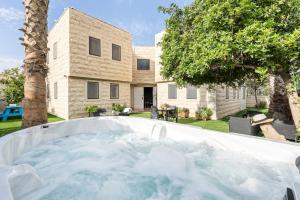 a large pool of water in front of a house at La Finca Luxury Suites Hotel in Beer Sheva