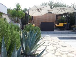 a patio with an umbrella in a yard at Apartment Nella Kostrena in Kostrena