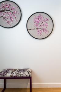 two paintings of a cherry tree on a wall with a bench at Apartamentos RG Plaza de España in Seville