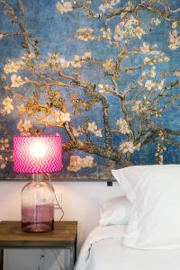 a lamp on a table in front of a painting at Apartamentos RG Plaza de España in Seville