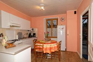 uma cozinha com mesa e cadeiras num quarto em gite de Sauviat 25 chemin du grand Pacher le bourg de Sauviat 63120 em Sauviat