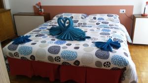 a bed with blue bows on top of it at Rosso Tirano in Tirano