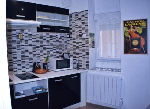 a kitchen with a microwave and a counter top at BéziersApart *** vivre à la française comme un habitant in Béziers