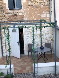 a pergola with a table and chairs on a patio at la Salaberie in Villeréal