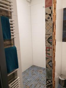 y baño con ducha y azulejos en el suelo. en Hotel Nacht-Quartier, en Willich