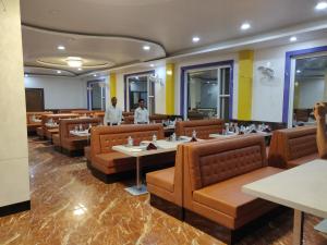 菩提伽耶Bodhgaya Seven Inn Hotel n Restaurant的一间设有棕色桌椅和两人餐厅