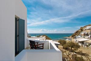 a balcony with a chair and the ocean at Perigiali Rooms & Apartments Folegandros in Agali