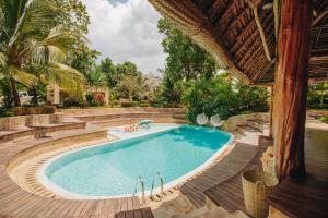 an outdoor swimming pool with a deck and stairs around it at Tulia Zanzibar Unique Beach Resort in Pongwe