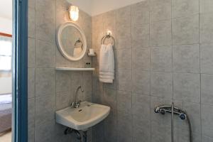 a bathroom with a sink and a mirror at Perigiali Rooms & Apartments Folegandros in Agali