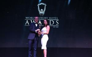 a man and woman standing on a stage holding a trophy at Tulia Zanzibar Unique Beach Resort in Pongwe
