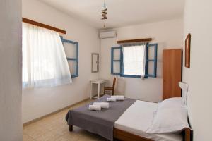 a bedroom with a bed with two towels on it at Perigiali Rooms & Apartments Folegandros in Agali