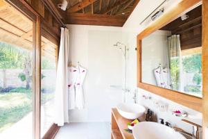 a bathroom with two sinks and a mirror at Tulia Zanzibar Unique Beach Resort in Pongwe