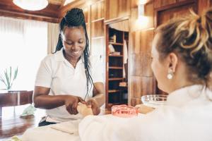 a woman cutting a piece of cake while another woman watches at Tulia Zanzibar Unique Beach Resort in Pongwe +37 photos