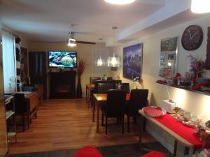 a dining room with tables and chairs and a tv at Hotel Saint-Donat in Saint-Donat-de-Montcalm
