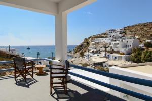 a balcony with chairs and a view of the ocean at Perigiali Rooms & Apartments Folegandros in Agali