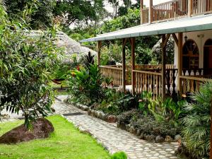 a garden with a stone path in front of a house at Banana Lodge in Puerto Misahuallí