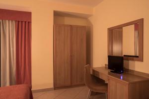 a hotel room with a desk with a television on it at Manhattan Village Hotel in Sulmona