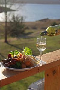 a plate of food and a glass of wine at Siesta Villa in Jindabyne