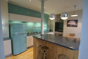 a kitchen with a blue refrigerator and a counter at Spacious 2 bed apt next to Royal Mile & Waverley in Edinburgh