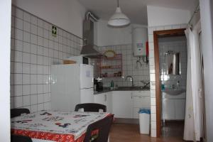 a kitchen with a table and a white refrigerator at Casa da Princesa in Vila Real de Santo António +24 photos