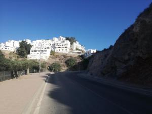 an empty street with white buildings on a hill at Sunny Apartment in Mojácar