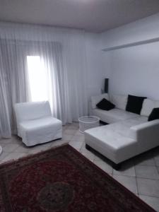 a living room with two white couches and a window at Villa Maria in Isola delle Femmine