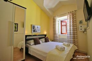 Postel nebo postele na pokoji v ubytování Apartment & Rooms Antonijela